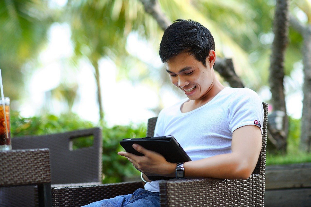 Man smiling checking his tablet